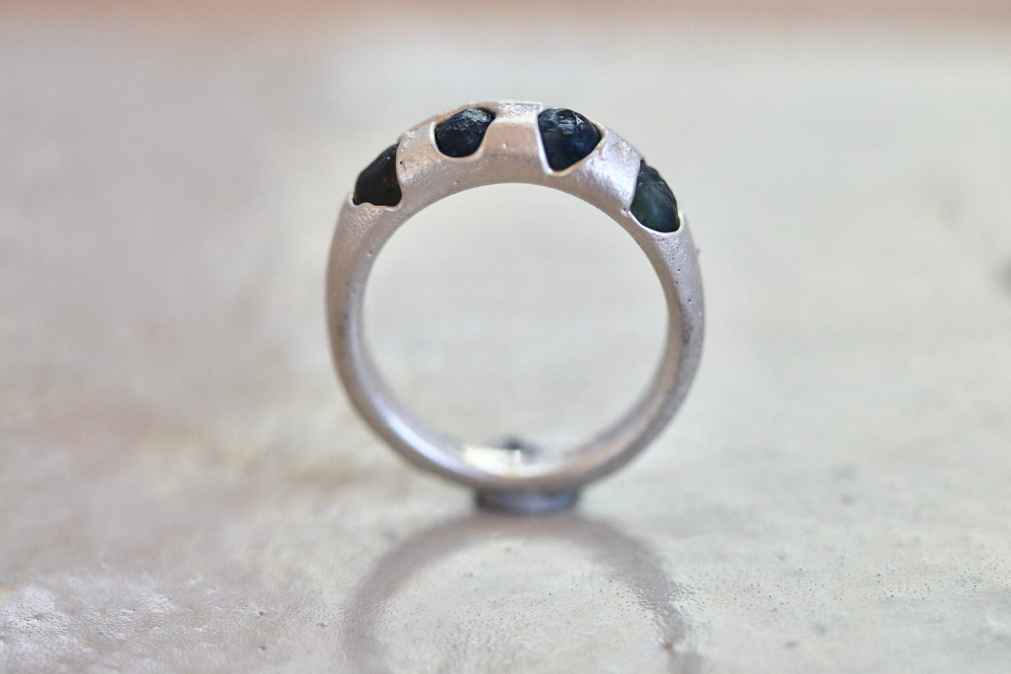 raw montana sapphire sandcast rough rustic earthy cast in place wedding thick silver band paige devlin jewelry ethical organic texture