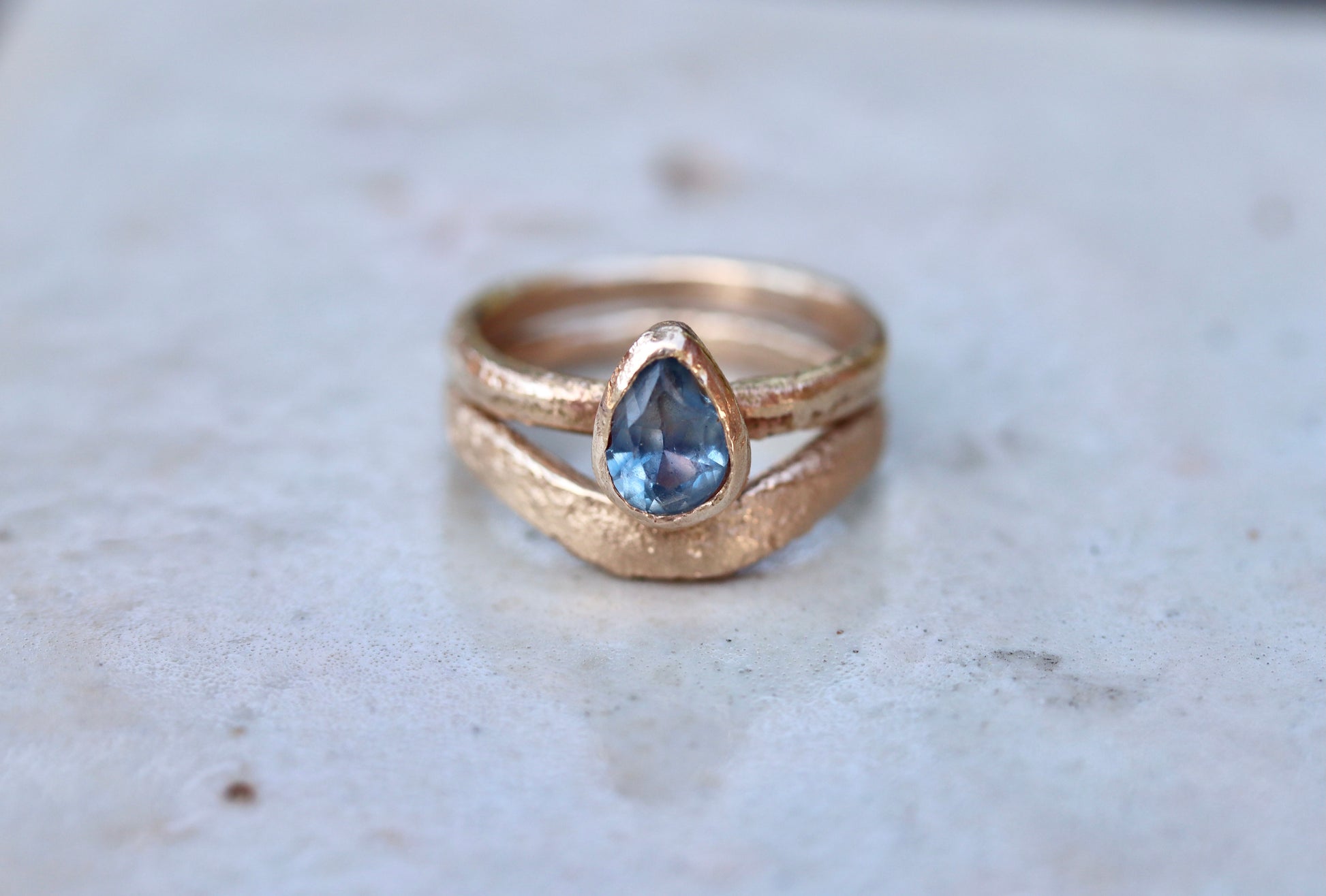 blue montana sapphire organic texture sandcast paige devlin jewelry 14kt gold handcrafted engagement ring pear shape yogo sapphire
