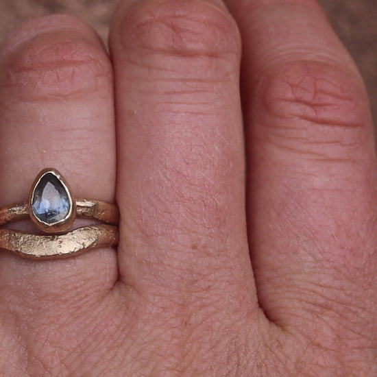 organic texture sandcast paige devlin jewelry 14kt gold handcrafted engagement ring arc curve band pear blue montana sapphire